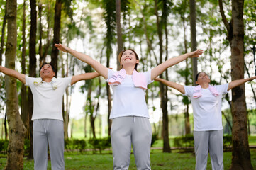 Obraz premium Daughter Joins Senior Parent for Heartwarming Exercise in Green Public Park, Senior Parent Exercise and Bonding Moments with Daughter, Supportive New Generation, Health Care in Retirement or Old Age.
