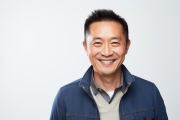 Medium shot portrait of a Chinese man in his 40s in a white background wearing a chic cardigan