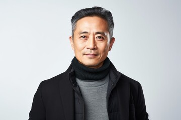 Medium shot portrait of a Chinese man in his 40s in a white background wearing a chic cardigan