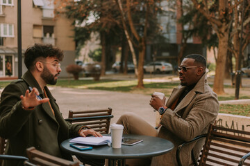 Black male business person listening to his white colleague explaining something about the new project. Sounds weird to him