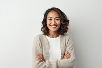Lifestyle portrait of a Indonesian woman in her 30s in a white background wearing a cozy sweater