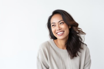 Lifestyle portrait of a Indonesian woman in her 30s in a white background wearing a cozy sweater