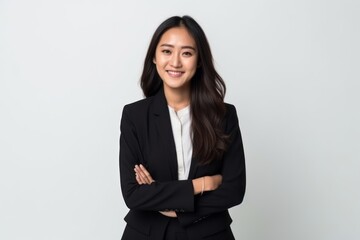Portrait of a smiling young asian businesswoman standing with arms crossed