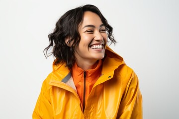 Fototapeta premium Portrait of a smiling young woman in a yellow raincoat on a white background