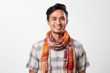 Portrait of a smiling young asian man wearing scarf standing against white background