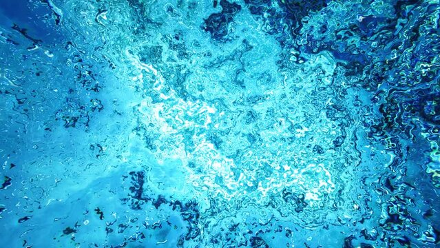 Underwater Looking up Abstract Background 4K Loop features liquid movement similar to looking at bubbles underwater or looking at caustics in a pool or water from underwater in a loop