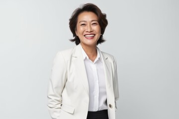 Portrait of a smiling asian businesswoman standing isolated over white background