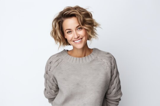 Lifestyle portrait of a Russian woman in her 30s in a white background wearing a cozy sweater
