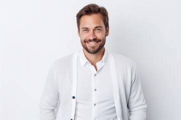 Fototapeta premium Lifestyle portrait of a Russian man in his 30s in a white background wearing a chic cardigan