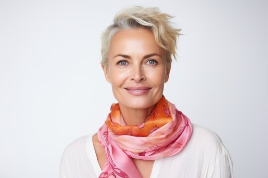 Portrait of a beautiful mature woman with short blond hair and a pink scarf