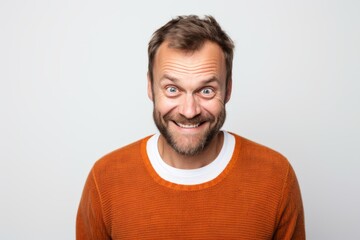 Fototapeta premium Portrait of a funny man in orange sweater on white background.