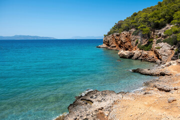 Greece, Dragonera beach in Agistri Island at Saronic Gulf. Pine tree, crystal sea, blue sky.