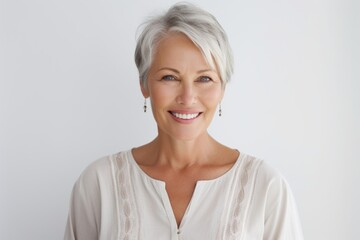 Portrait of a smiling senior woman looking at camera over white background