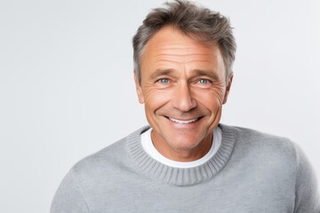 Close-up portrait of a Russian man in his 50s in a white background wearing a chic cardigan