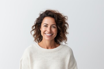 Fototapeta premium Close-up portrait of a Brazilian woman in her 40s in a white background wearing a cozy sweater