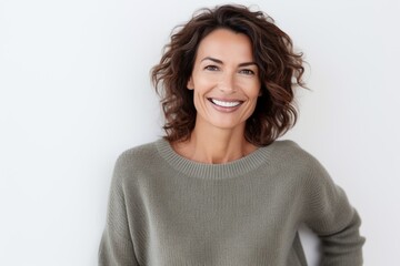 Lifestyle portrait of a Brazilian woman in her 40s in a white background wearing a cozy sweater