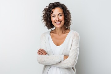 Lifestyle portrait of a Brazilian woman in her 40s in a white background wearing a chic cardigan