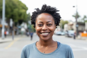 Close-up portrait of a Nigerian woman in her 30s in a white background wearing a casual t-shirt