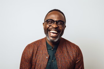 Lifestyle portrait of a Nigerian man in his 40s in a white background wearing a chic cardigan