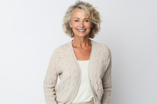 Portrait Of Smiling Senior Woman Standing With Arms Crossed Against White Background