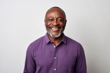 Fototapeta premium Portrait of a smiling mature African American man standing against white background
