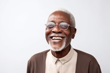 Fototapeta premium Medium shot portrait of a Nigerian man in his 70s in a white background wearing a chic cardigan