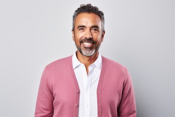 Portrait of a handsome middle-aged man smiling at the camera while standing against grey background
