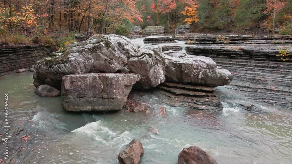 Wall mural multiple waterfalls flow over rock cascade in the mountains during autumn with fall colored forest t