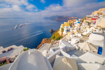 The famous panoramic view of the sights of Santorini - white houses, blue domes and yachts in the azure sea. Oia, Santorini island, Greece, Europe.