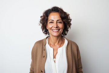 Fototapeta premium Portrait of smiling businesswoman with curly hair against white background.