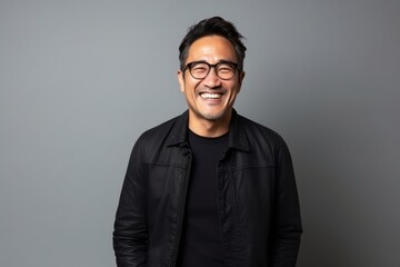 Obraz premium Portrait of a smiling asian man in black jacket and eyeglasses