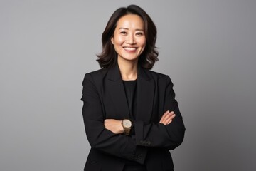 Portrait of a smiling asian businesswoman standing with arms crossed