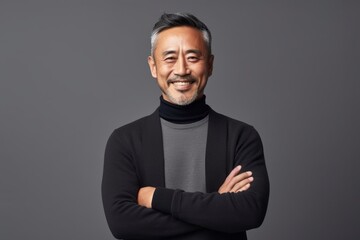 Obraz premium Portrait of a smiling middle-aged asian man with crossed arms