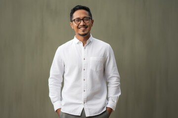 Obraz premium Portrait of young indian businessman wearing eyeglasses against grey background