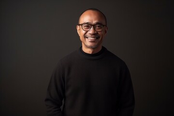 Obraz premium Portrait of a happy asian man wearing glasses on black background