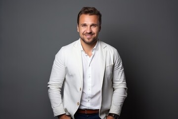 Obraz premium Portrait of handsome young man in white shirt on grey background.