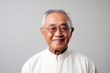 Fototapeta premium Portrait of a senior asian man wearing eyeglasses on grey background