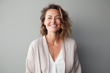 Obraz premium Portrait of a happy young woman smiling at camera isolated over gray background