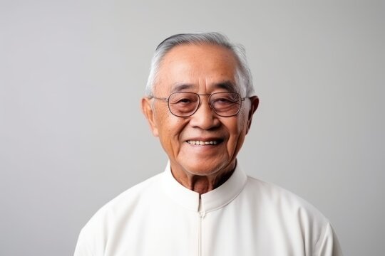 Portrait of a senior asian man wearing eyeglasses on grey background