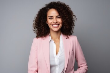 Portrait of a smiling young businesswoman standing isolated over gray background