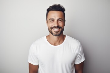 Lifestyle portrait of a Brazilian man in his 30s in a minimalist or empty room background wearing a simple tunic - obrazy, fototapety, plakaty