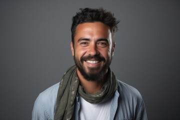 Obraz premium Portrait of a handsome young man with beard and scarf on grey background