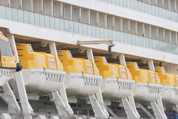 A row of lifeboats on a large cruise ship
