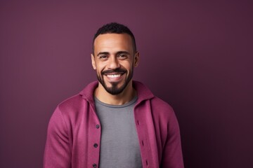 Obraz premium Portrait of a smiling african american man standing against purple background