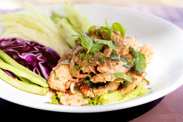 Spicy grilled pork salad (Moo Yang Nam Tok) on white plate. Traditional Thai food recipe.