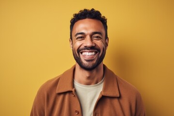 Obraz premium Portrait of a smiling african american man over yellow background