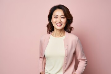 Portrait of smiling asian woman on pink background with copy space