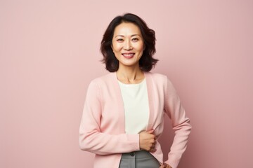 Obraz premium Portrait of a smiling young asian businesswoman isolated over pink background