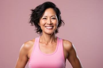 Fototapeta na wymiar Smiling asian woman in sportswear posing on pink background