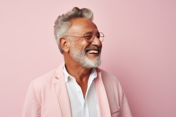 Lifestyle portrait of a Brazilian man in his 70s in a pastel or soft colors background wearing a...